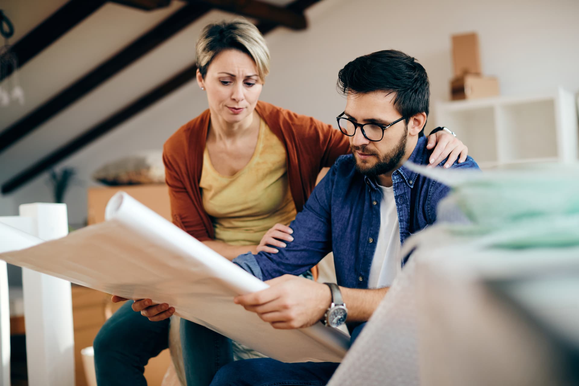 Couple étudiant les plans de sa future maison